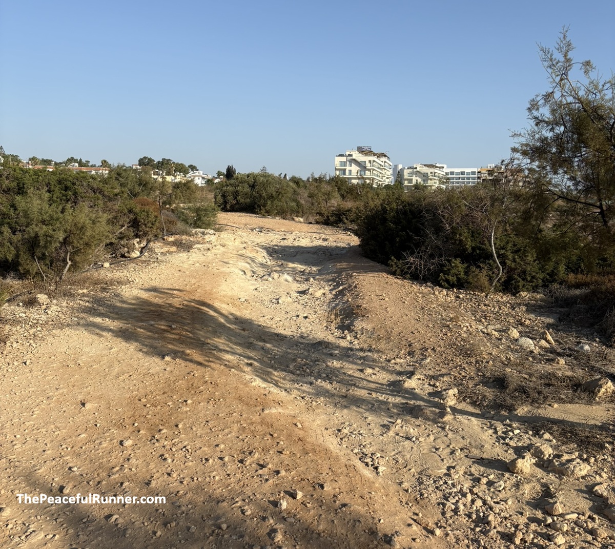 Running on rough trail in Protaras, Cyprus Rough, rocky section of the natural trail south of Protaras with hotels on the ridge behind